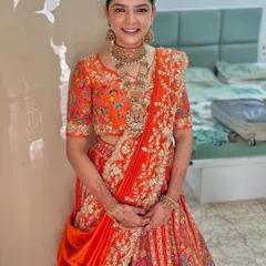 A full view of the happy bride, ready for her big day. The elegant bun complements her intricate jewelry and stunning outfit perfectly.