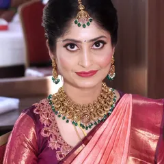 A classic and elegant makeover. This look features sharp, defined eyes with a winged liner, a bold red lip, and antique gold jewelry with green stones that perfectly match the maang tikka.