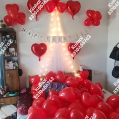 Another view of the romantic bedroom setup, showing the "Happy Birthday" banner and heart foil balloons.