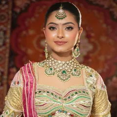 A frontal view showcasing the complete bridal ensemble. The intricate work on the lehenga blouse is perfectly complemented by the grand Kundan necklace, creating a picture-perfect look for any bride.