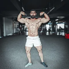 A powerful front double bicep pose, showcasing symmetry and conditioning. This is the result of countless hours of training and dieting, presented with confidence.