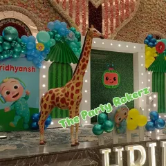 For this large-scale Cocomelon party, I included a life-sized giraffe prop to add a 'wow' factor. The decor also features a custom backdrop and character cutouts.