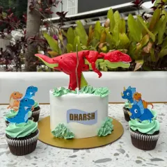 This dinosaur themed birthday set was for a huge T-Rex fan. The main cake is a simple, elegant design topped with a toy, surrounded by matching chocolate cupcakes with little dinosaur toppers.