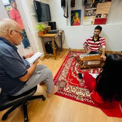 An adult student observes a Hindustani vocal lesson, highlighting our open environment where parents or aspiring students can see our teaching methods firsthand.