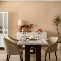 I believe a dining room should be the heart of the home, a place that naturally draws people together. Here, the warm, earthy tones on the walls and the elegant marble tabletop create an inviting atmosphere for shared meals and conversations. The space is completed with a simple white crockery unit and touches of red and brass, making it feel cherished and lived-in.