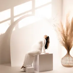 The same minimalist setup, with the mother-to-be basking in the sunlight. This pose emphasizes the beauty and grace of the baby bump.