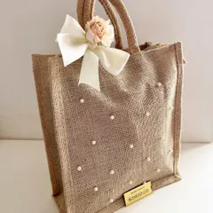An elegant and eco-friendly option for return gifts. This pearl-studded jute bag is perfect for filling with favors and can be reused by your guests. The floral and ribbon detail adds a touch of sophistication.
