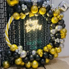A classic black, gold, and silver balloon ring. This decoration includes a neon sign and is perfect for creating a stylish photo corner at any adult birthday party.