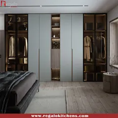 This floor-to-ceiling wardrobe in a soft blue-grey finish is designed to maximize storage in the bedroom. It features integrated display niches with backlighting for showcasing decor.