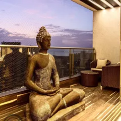 What could be better than a gorgeous balcony with a beautiful Buddha statue? This space is designed for calm reflection, with a comfortable seating area and a view of the evening sky.