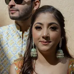 A candid portrait of a couple from their engagement or pre-wedding event. The warm sunlight and their happy expressions capture a moment of love and connection.