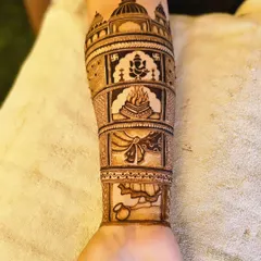 This arm design is a story of wedding rituals. It features panels with Lord Ganesha for blessings, the sacred fire (agni), the tying of the knot (gathbandhan), and the doli.