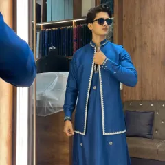 A perfect look for a wedding guest. This custom-stitched royal blue kurta is paired with an open jacket featuring delicate white border embroidery. It’s a modern, elegant, and comfortable choice that ensures you stand out with class at any celebration.