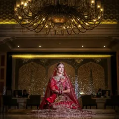 A majestic bridal portrait, with the bride seated on the floor in a grand hotel lobby. The low angle and opulent background create a sense of royalty and scale.
