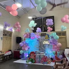 This wide view shows how I transformed a hall for the Little Mermaid party, with the main stage as the focal point and balloon clusters floating from the ceiling to create an underwater feel.