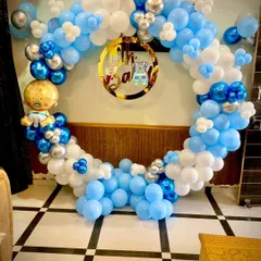 An "Oh Baby" themed decoration perfect for a baby shower or a baby's first birthday. This circular balloon arch in shades of blue and white is accented with chrome silver and a cute baby boy foil balloon.