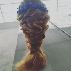 A soft and romantic messy fishtail braid, topped with a delicate blue floral crown. This bohemian-inspired hairstyle is perfect for outdoor pre-wedding photoshoots or a relaxed party look.