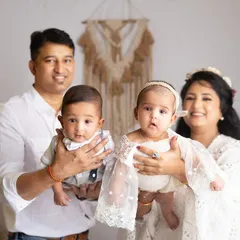 A classic family portrait with the proud parents holding their twin babies. Capturing a family of four is a beautiful milestone.