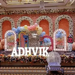 I design large scale, themed birthday parties for kids that bring their favorite characters to life. This Cocomelon stage setup for Adhvik's welcome party includes character cutouts, marquee letters for the name, and multiple balloon-filled arches for a grand entrance.