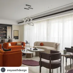 In collaboration with Sreya Seth Design, we crafted furniture for this elegant living room. The space features a vibrant orange sofa that brings a pop of color, balanced by a gracefully curved sofa in a neutral tone. The organic shapes of the marble-topped coffee tables add a sculptural element to the room.