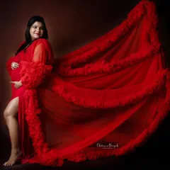 The drama of a long train. We used a dark background to make this vibrant red gown pop, creating a powerful and artistic maternity portrait.
