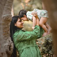 A mother's love captured in an outdoor setting. This beautiful shot of a mom lifting her son into the air is full of joy and tenderness.
