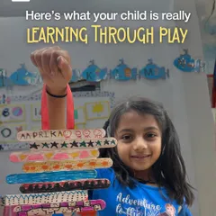 This is what learning through play really looks like. This proud artist is showing off her colorful creation made from simple ice cream sticks, an activity that builds fine motor skills and pattern recognition.