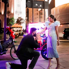 A proposal moment captured on the streets of London. Her light blue Tanieya Khanuja dress with ruffled shoulders added a touch of modern fairytale romance to the city night.