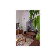 A quiet seating area where restored wooden furniture and a classic archway frame the space. We focused on creating intimate nooks within the larger, open-plan layout for personal moments.