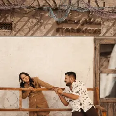 A playful and charming moment outside a Starbucks in a traditional Arabian setting. This shot perfectly blends modern life with cultural charm.