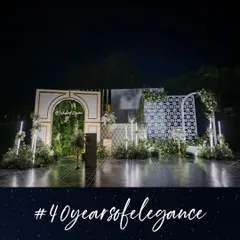 This elegant stage and photobooth, created for a '40 Years of Elegance' celebration, combined a lush vertical garden with modern architectural panels and a custom neon sign. It provided a sophisticated backdrop for photos.