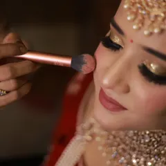 Building that perfect bridal glow. Here, I am applying blush to the apples of the cheeks, a fundamental technique for adding warmth and dimension to the face.