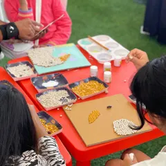 At our art and craft tables, kids are free to create their own masterpieces. Here, children are focused on making beautiful mosaics with colorful grains, an activity that is both fun and great for concentration.