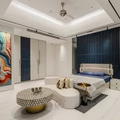 A wide view of this spacious bedroom, showcasing the stunning panoramic view, the custom wardrobes with blue accents, and the unique curved lounge sofa. The design is modern, serene, and perfect for a young adult.