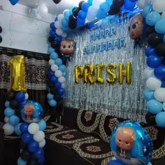 A first birthday party with a Boss Baby theme. I used a blue, black, and white color scheme with a foil curtain backdrop, character balloons, and a large number '1' foil balloon.