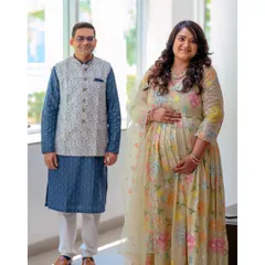 A full-length portrait of the couple, showcasing their coordinated outfits and happy smiles. This shot captures the celebratory feel of their maternity journey.