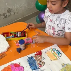 Getting hands on with different materials like clay, pom poms, and paper. This sensory experience is a great way for young kids to explore their creativity.
