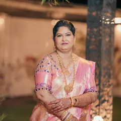 A full-length shot of the bride's mom, looking graceful in her pink silk saree. The makeup is designed to be flattering and long-lasting.