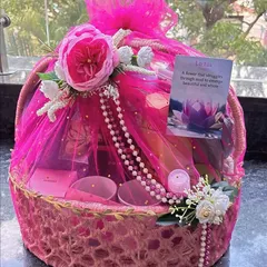A hamper filled with everyday essentials for a bit of pampering. This basket is wrapped in vibrant pink tulle and includes skincare, a pearl necklace detail, and an inspirational card.