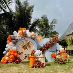 A look at my "Tangerine & Twinkles" baby shower theme, where we used an arch backdrop, custom seating, and vibrant balloon garlands. I love incorporating unique elements like real santras into the floral arrangements for a fresh, memorable touch.