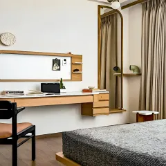 This minimalist bedroom workspace features a sleek floating desk with built-in drawers and a whiteboard. The design is clean, uncluttered, and perfectly integrated with the room's aesthetic.