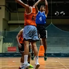 An All-Star player goes for a layup against a strong defense during a charity basketball match. This action shot captures the competitive spirit of the games hosted at our facility.