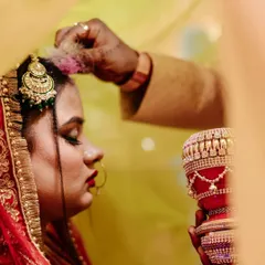 The Sindoor Daan is one of the most profound moments in an Indian wedding. I framed this shot to focus on the bride's reverent expression and the gentle application of the sindoor, capturing the solemnity and emotion of this sacred ritual.