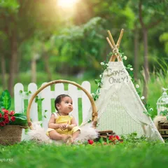 My outdoor sessions in Bangalore's beautiful green spaces offer a natural and light-filled backdrop. This boho-themed setup with a teepee and floral accents is perfect for sitter sessions and milestone photos.