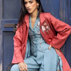 A powerful statement in color and texture. This look combines a powder blue embroidered bustier and trousers with a contrasting rust-colored silk jacket for a bold, contemporary fusion style.