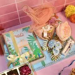 A complete view of our stunning Rakhi hamper. It includes a box of assorted Indian fusion sweets, a jar of biscotti, and a beautiful Rakhi, all presented on an elegant, decorated tray.