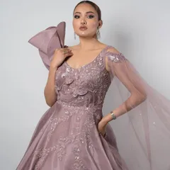 This pastel lavender gown is the definition of modern elegance. The structured bow on the shoulder and flowing sheer sleeve add a high-fashion touch, perfect for a sangeet or reception.