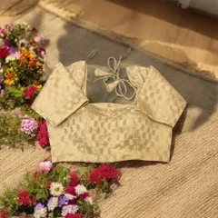 A gold brocade blouse is a timeless classic. This elegant piece with a sheer back and delicate ties can be paired with almost any saree for an instantly graceful look.