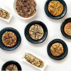 An assortment of our breads, including the flaky chur chur paratha and various stuffed kulchas. Each one is designed to be an integral part of our inventive Indian food philosophy.