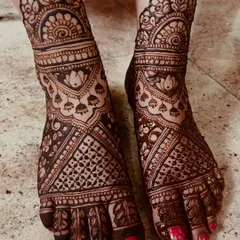 Bridal mehendi isn't complete without adorning the feet. This design features dense, intricate patterns covering the entire foot, with beautiful lotus and jhumka motifs that complement the hand henna perfectly.